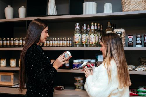 two women are standing in a storeacistacistangering at Collegare Hotel in Capitólio