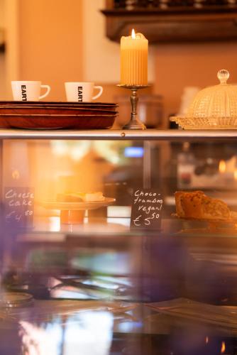 a glass display case with cakes and cups and a candle at Pieks Noordlaren in Noordlaren