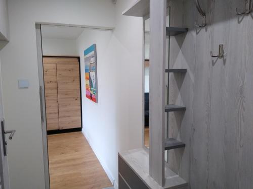 a hallway of a house with shelves and a door at Apartament Bocianek in Kielce