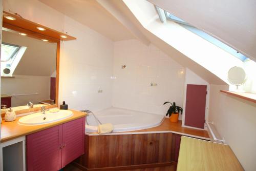 a bathroom with a bath tub and a sink at Longère des Alix in Pornichet