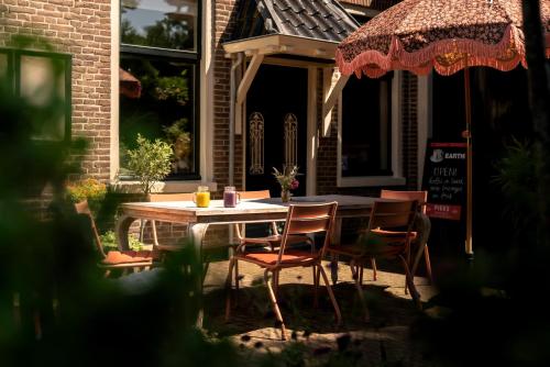 a wooden table and chairs on a patio at Pieks Noordlaren in Noordlaren
