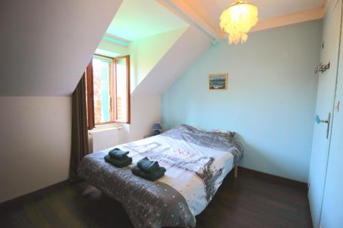a bedroom with a bed with two black shoes on it at Longère des Alix in Pornichet