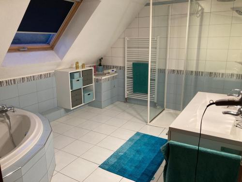 a bathroom with a tub and a sink and a shower at Villa au calme avec piscine et jacuzzi in Riedwihr