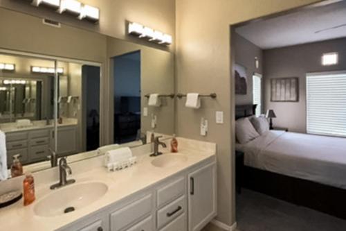 ein Badezimmer mit zwei Waschbecken und ein Schlafzimmer mit einem Bett in der Unterkunft Vistoso Resort Casita #165 in Tortolita