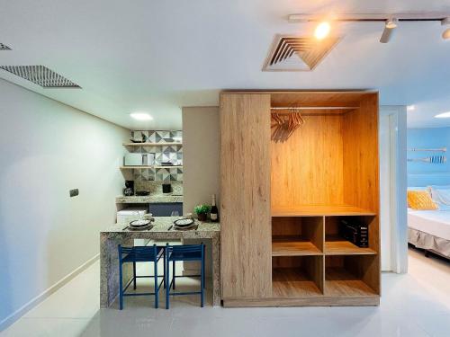 a kitchen with a island in a room with a bed at Luxo Frente Mar | Nobile #220 in Tambaú