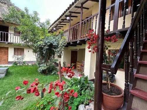 un jardin avec des fleurs rouges et un escalier dans l'établissement Casa Paqocha Garden - Ollantaytambo - Hot Water - Wifi - Cocina Compartida, à Ollantaytambo