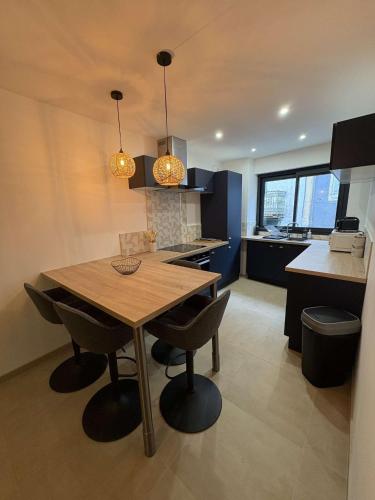 a kitchen with a wooden table and some chairs at Appartement fraîchement rénové plein cœur du village in Saint-Fortunat-sur-Eyrieux
