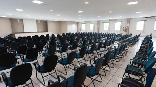 a room with rows of chairs in a classroom at Hotel Dan Inn Franca & Convenções By Nacional Inn in Franca