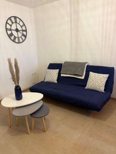a living room with a blue couch and a table at Appartement fraîchement rénové plein cœur du village in Saint-Fortunat-sur-Eyrieux