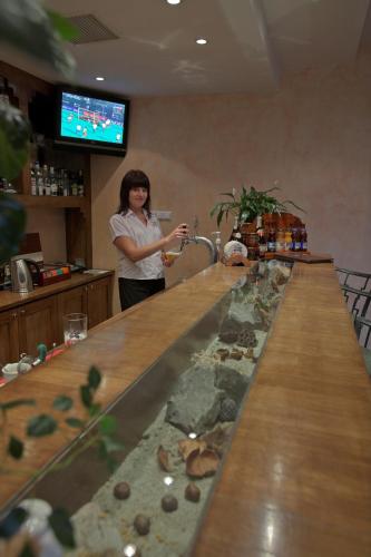 a woman standing at a bar with a faucet at Hotel REDYK Ski&Relax in Zakopane