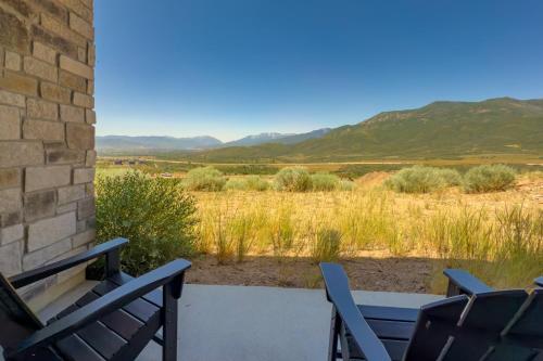 a patio with two chairs and a table and mountains at Scenic Mountain Stay Near Deer Valley Ski! in Heber City