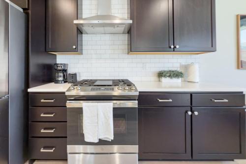 a kitchen with black cabinets and a stove at Scenic Mountain Stay Near Deer Valley Ski! in Heber City