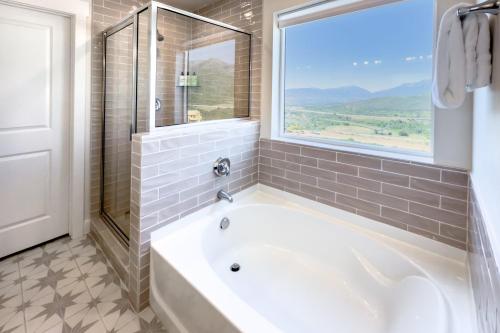 a white tub in a bathroom with a window at Scenic Mountain Stay Near Deer Valley Ski! in Heber City