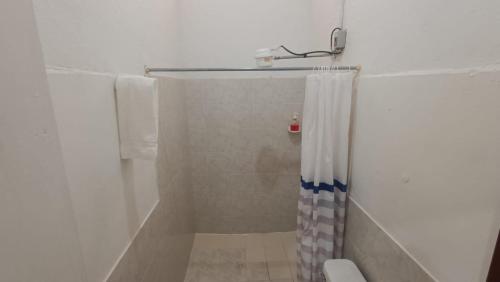 ein Bad mit Dusche und Duschvorhang in der Unterkunft ECOXPLORA-Casa de campo in Jardin