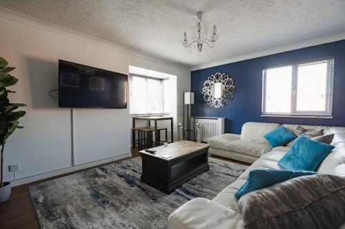 a living room with a couch and a table at Hullidays - 'Old School Penthouse' Trinity Square in Hull