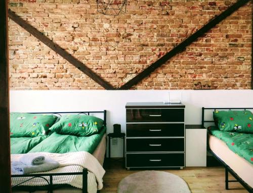 a living room with a couch and a brick wall at Apartament rodzinny SAKURA in Jędrzejów