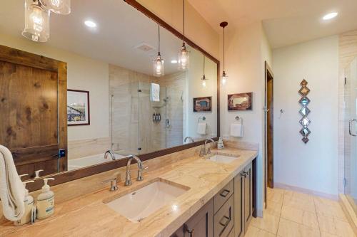Un baño con dos lavabos y un espejo grande. en Bangtail Getaway, en Steamboat Springs