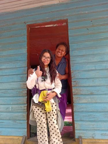 two women sitting in the doorway of a house at PeciJosh Homestay in Ngunu