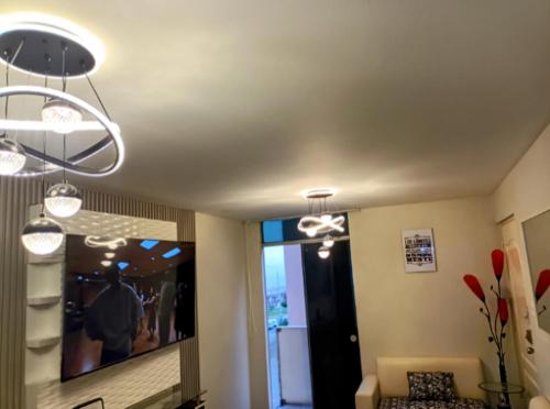 a living room with two lights hanging from a ceiling at Suite vista al mar San Miguel in Lima