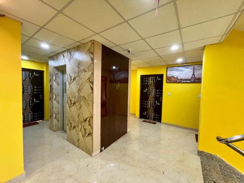 a hallway with yellow walls and a wooden elevator at The Little Heaven Hotel near Kolkata Airport in kolkata