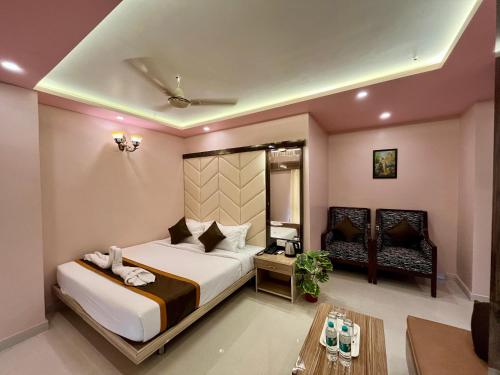 a bedroom with a large bed and a table at The Little Heaven Hotel near Kolkata Airport in kolkata