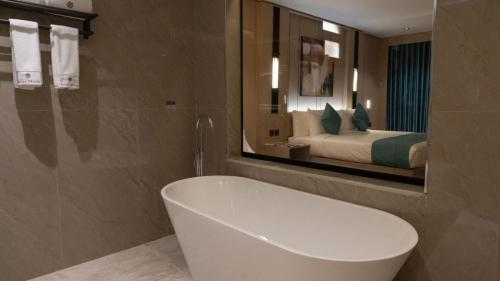 a bathroom with a tub and a bed in a mirror at فندق روزا جراند غرناطه in Riyadh