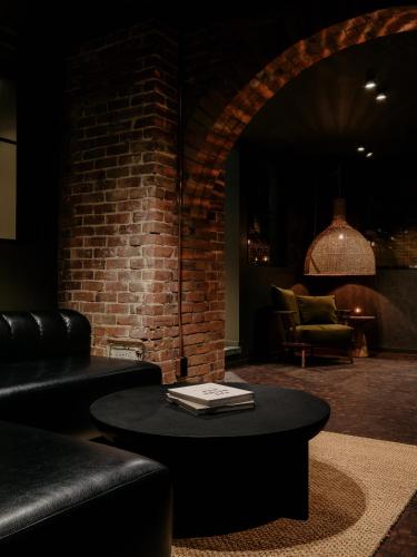 a living room with a table and a brick wall at Maison Grinder in Montréal