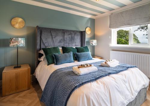 a bedroom with a large bed with towels on it at Priory Bay Escapes - Alba in Tenby