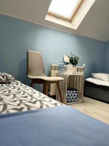 a bedroom with a bed and a chair and a skylight at Karczma gę gę gę Pokoje in Połajewo