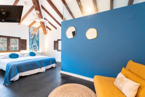 a blue bedroom with a bed and a couch at 1893 Hotel Boutique in Navajas