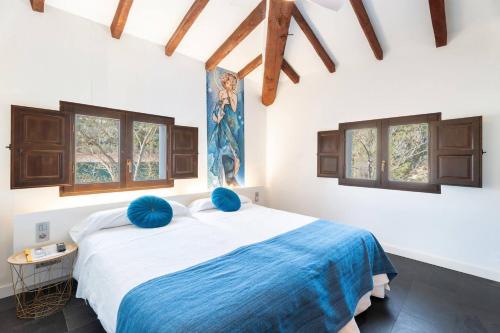 a bedroom with a large bed with blue pillows at 1893 Hotel Boutique in Navajas