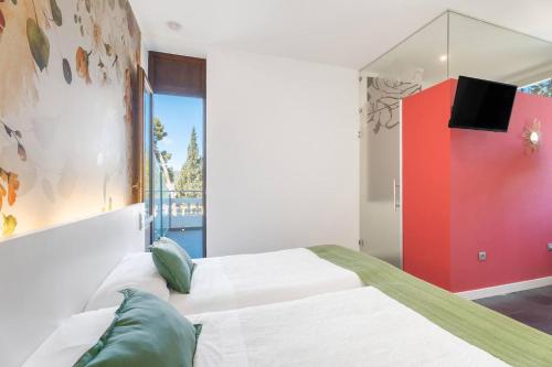 a bedroom with two beds and a tv on the wall at 1893 Hotel Boutique in Navajas