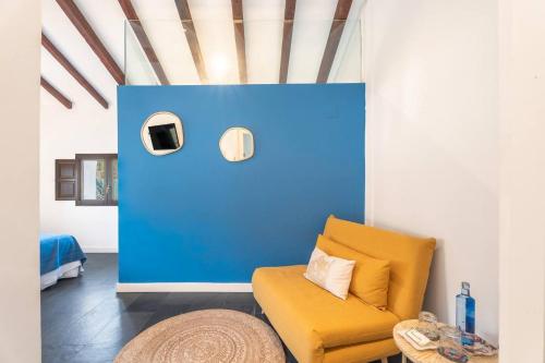 a living room with a yellow chair and a blue wall at 1893 Hotel Boutique in Navajas