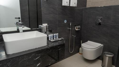 a bathroom with a sink and a toilet at Rosa Grand Hotel in Riyadh