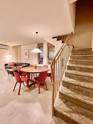 a dining room and living room with a table and chairs at 3BR Gem Steps from Shuk Machne Yehuda in Jerusalem