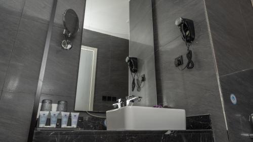 a bathroom with a sink and a mirror at Rosa Grand Hotel in Riyadh