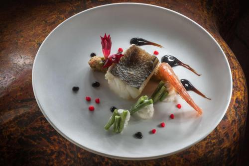 a plate of food with vegetables on a table at NH Collection Genova Marina in Genova
