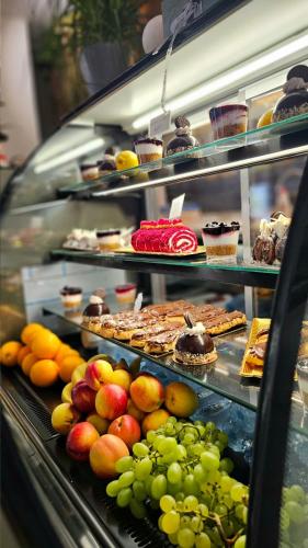 a display case filled with lots of different types of food at Hotel Ambasada QTA in Patza-Kuqani