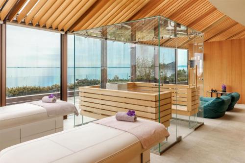 two beds in a room with a view of the ocean at Tivoli Portopiccolo Sistiana Apartments in Sistiana