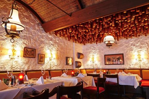 a dining room with white tables and chairs and a wall at Steigenberger Graf Zeppelin in Stuttgart