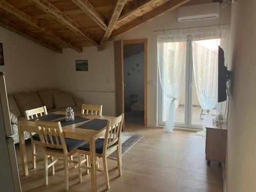 Un comedor con una mesa y sillas y un sofá. en Apartmani Matković, en Žuljana