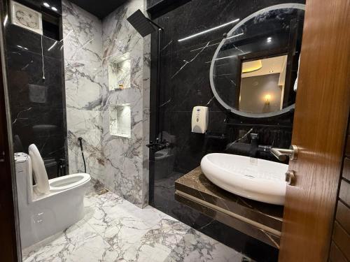 a bathroom with a sink and a toilet and a mirror at 2 bedrooms with attached baths in Karachi