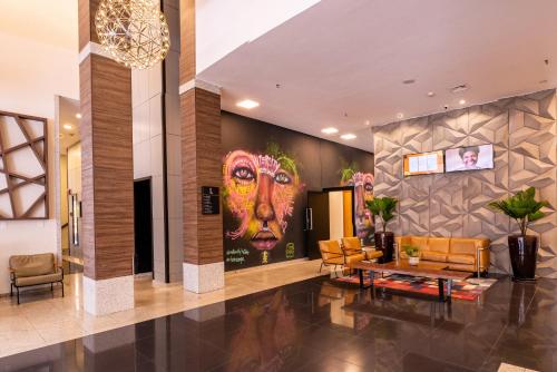 a lobby with a large painting of a woman at Intercity São Paulo Nações Unidas in Sao Paulo