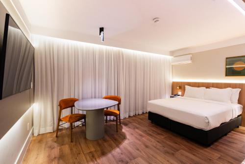 a hotel room with a bed and a table and chairs at Intercity São Paulo Nações Unidas in Sao Paulo