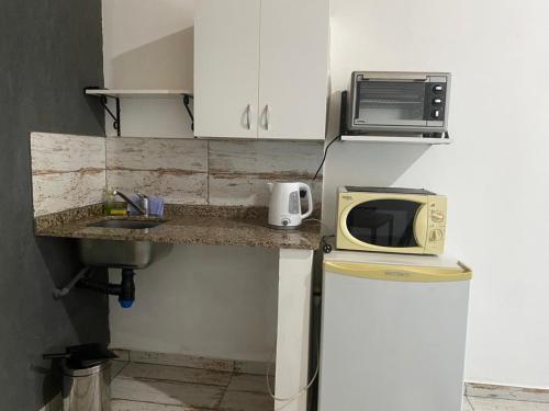 a small kitchen with a microwave and a sink at Complejo LA MERLINA in Merlo