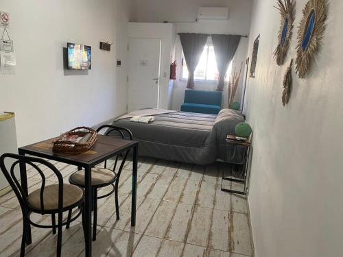 a bedroom with a bed and a table and chairs at Complejo LA MERLINA in Merlo