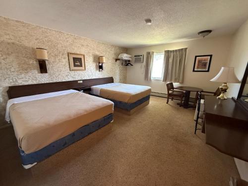 Una habitación de hotel con dos camas y un escritorio. en Hotel O The Kings Inn Culberston MT HWY 2, 