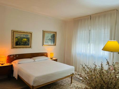 a white bedroom with a bed and a window at Luxury Relax Apartment near Venice Station in Venice