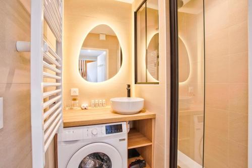 een badkamer met een wasmachine en een wastafel bij Le Morny Palace - Hyper Centre in Deauville
