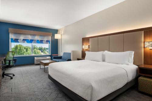 a hotel room with a large bed and a desk at Holiday Inn Express Queensbury-Lake George Area by IHG in Queensbury